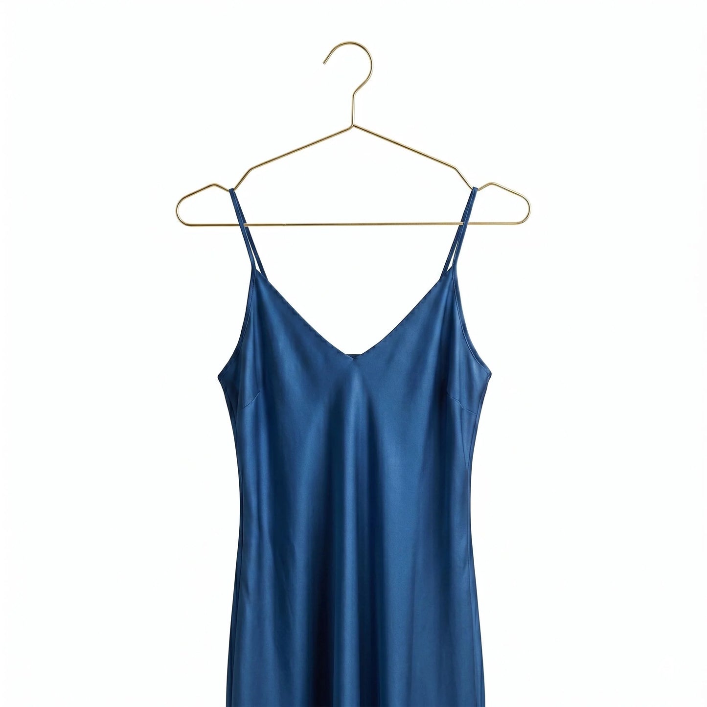Blue slip dress on a gold hanger against a white background