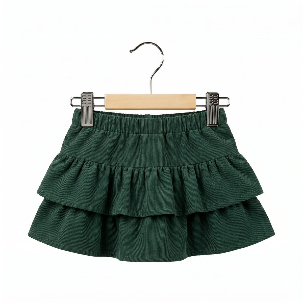Green ruffled skirt on a wooden hanger against a white background