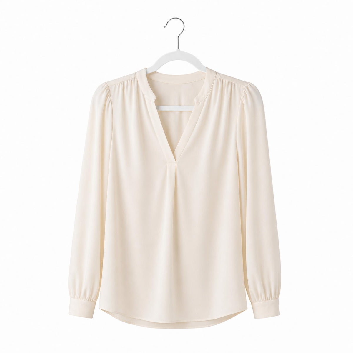 Beige blouse on a hanger against a white background