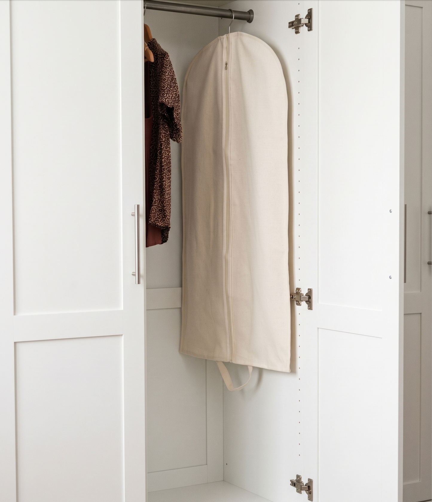 White garment bag hanging inside a white wardrobe