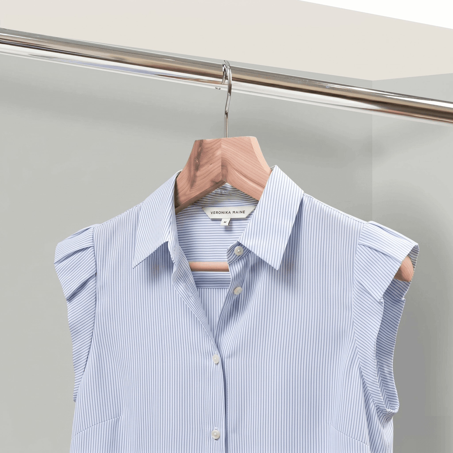 Light blue striped shirt on a hanger against a neutral background