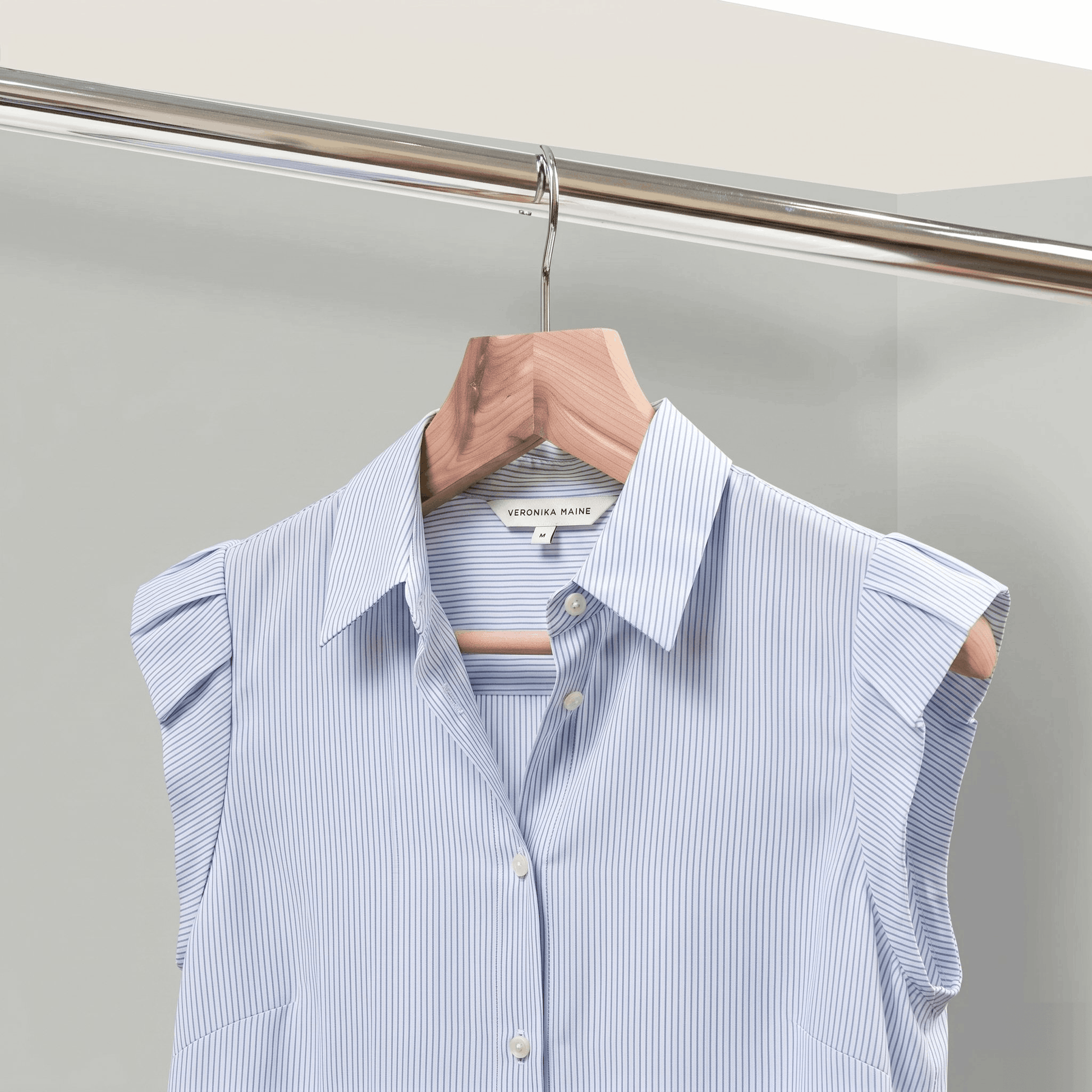 Light blue striped shirt on a hanger against a neutral background