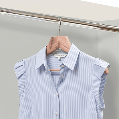 Light blue striped shirt on a hanger against a neutral background
