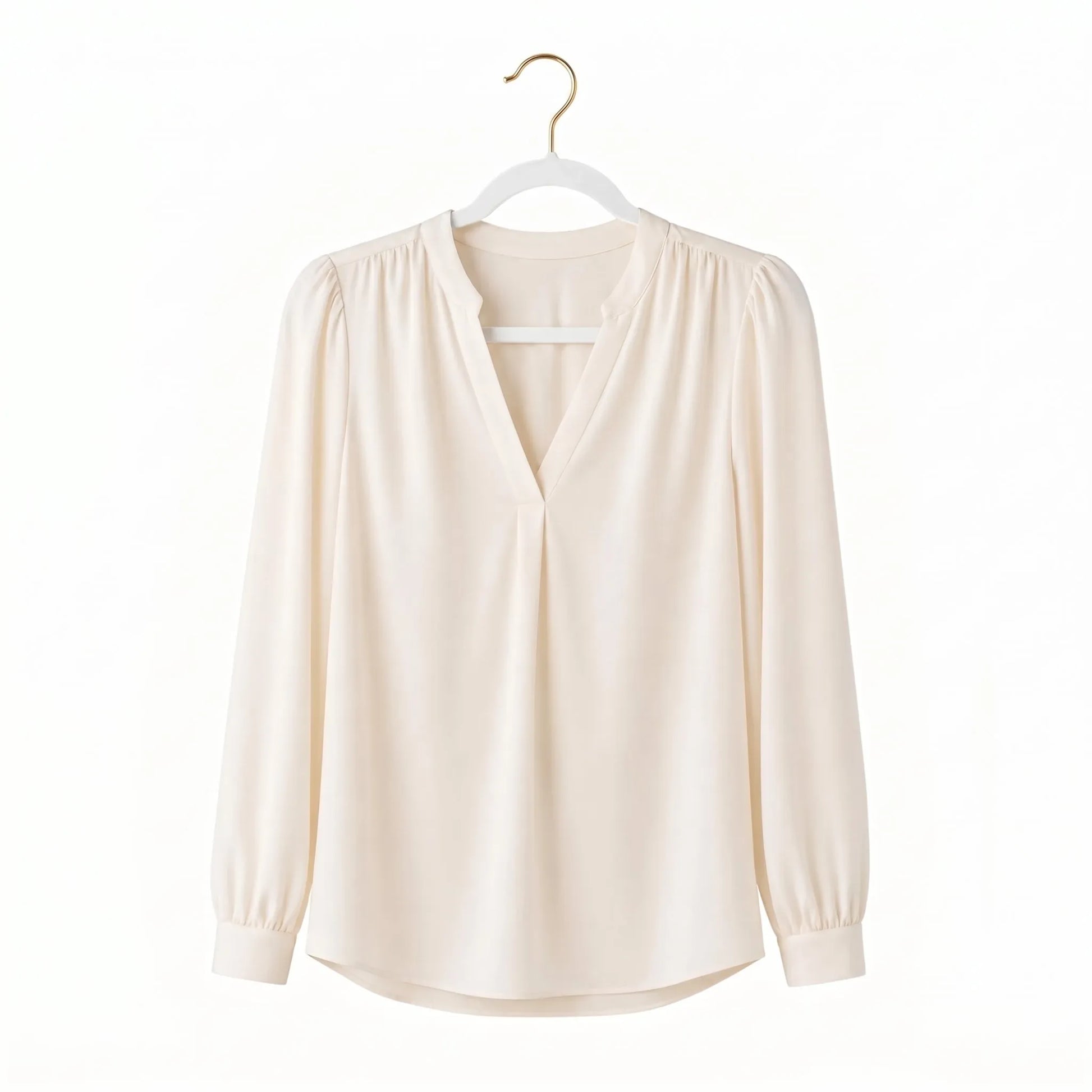 Beige blouse on a hanger against a white background