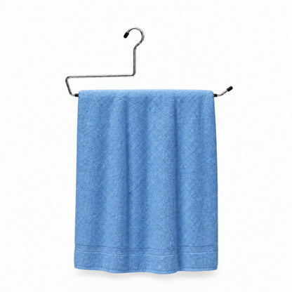 Blue towel hanging on a metal rack against a white background
