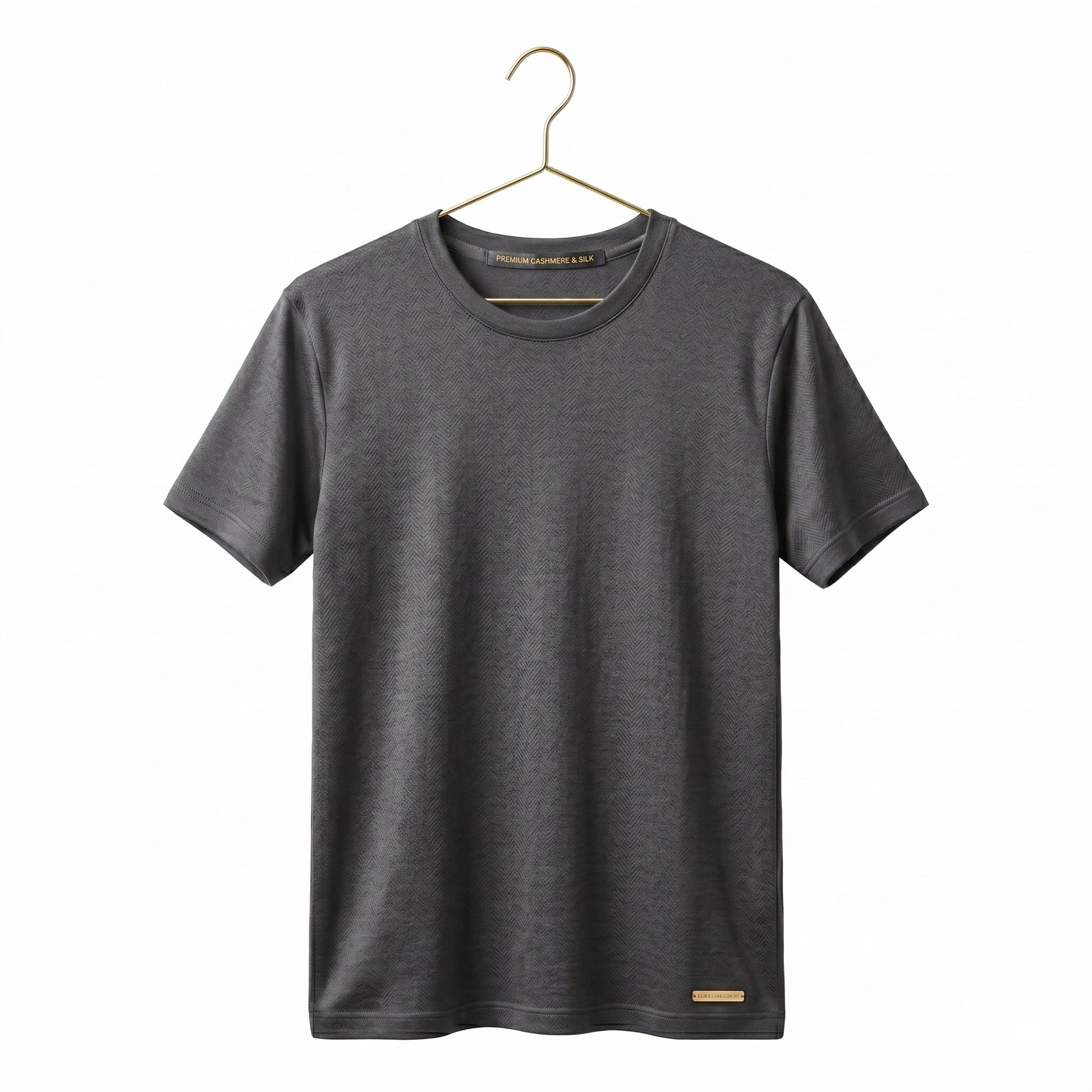 Grey short-sleeve shirt on a gold metal coat hanger against a white background