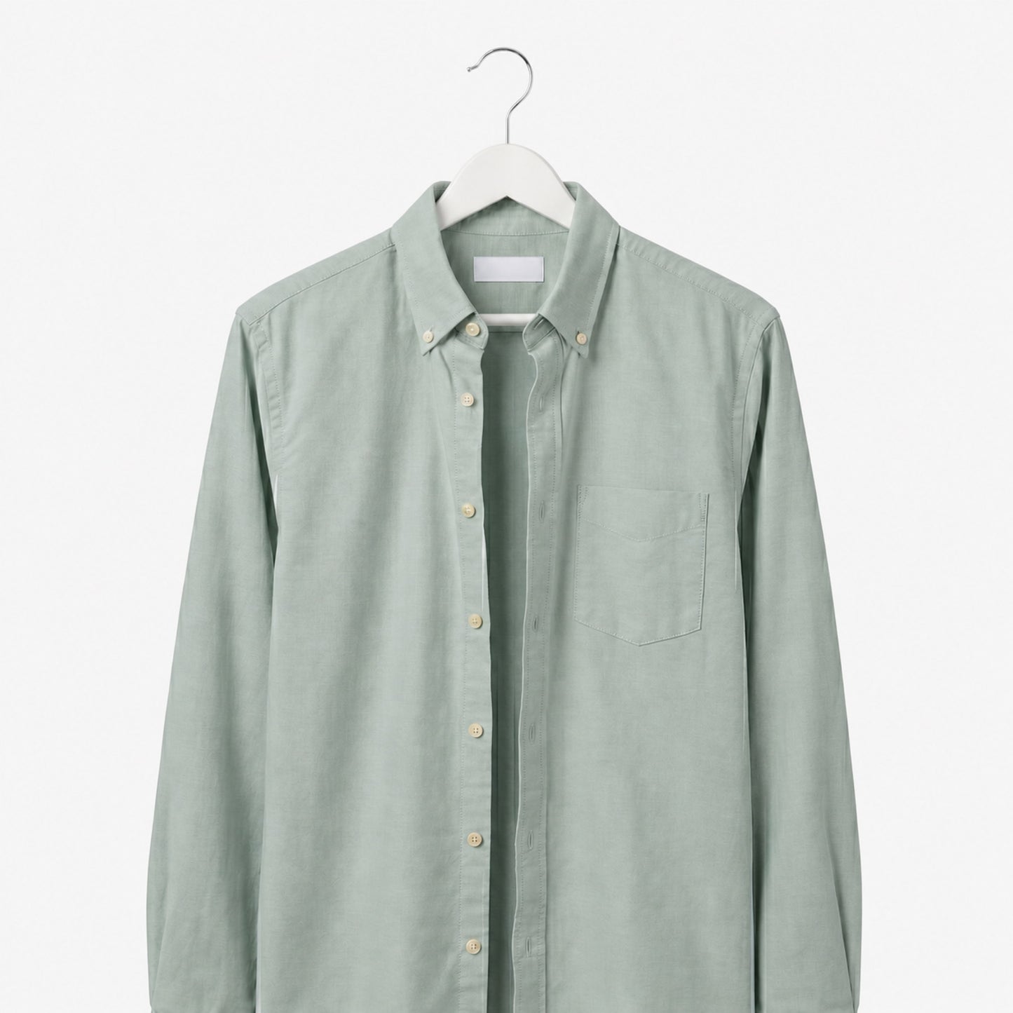Light green shirt on a hanger against a white background