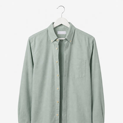 Light green shirt on a hanger against a white background