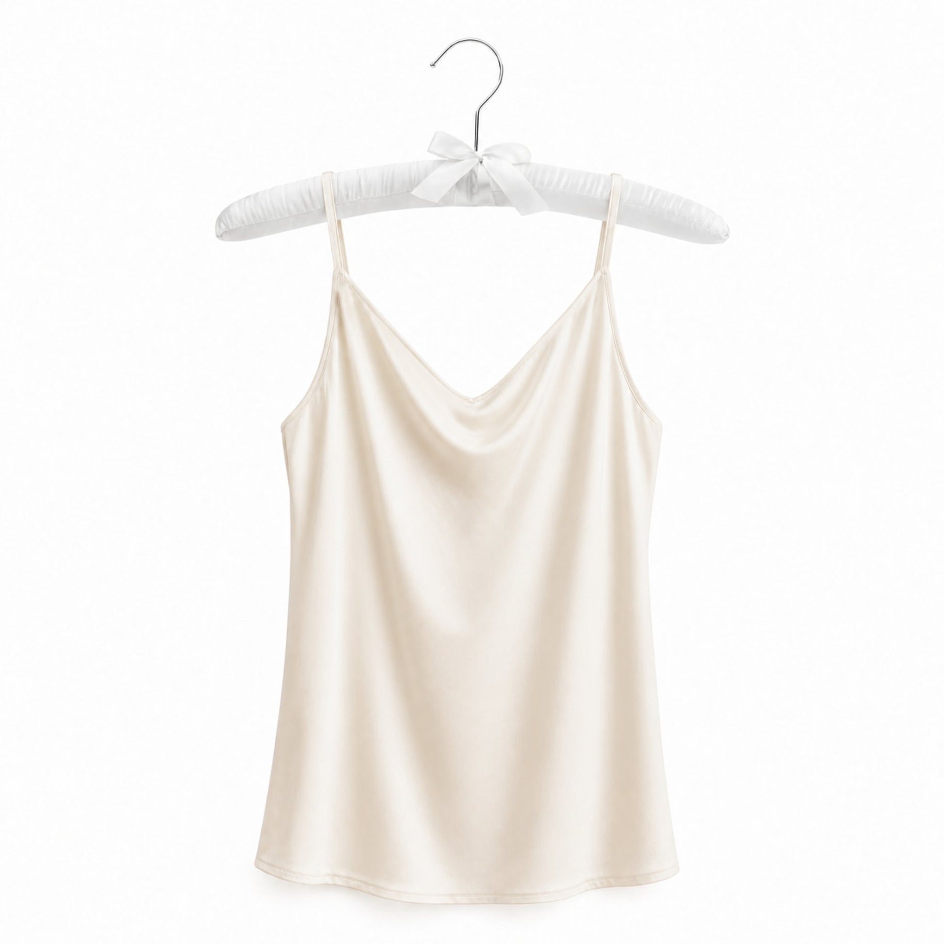 Beige satin camisole on a hanger against a white background