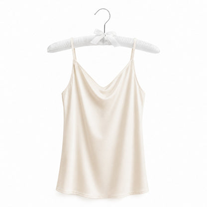 Beige satin camisole on a hanger against a white background